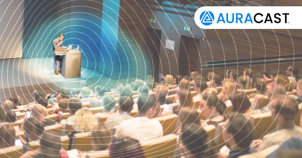 Presenter and audience in a lecture theatre, with illustrated Auracast audio coverage.